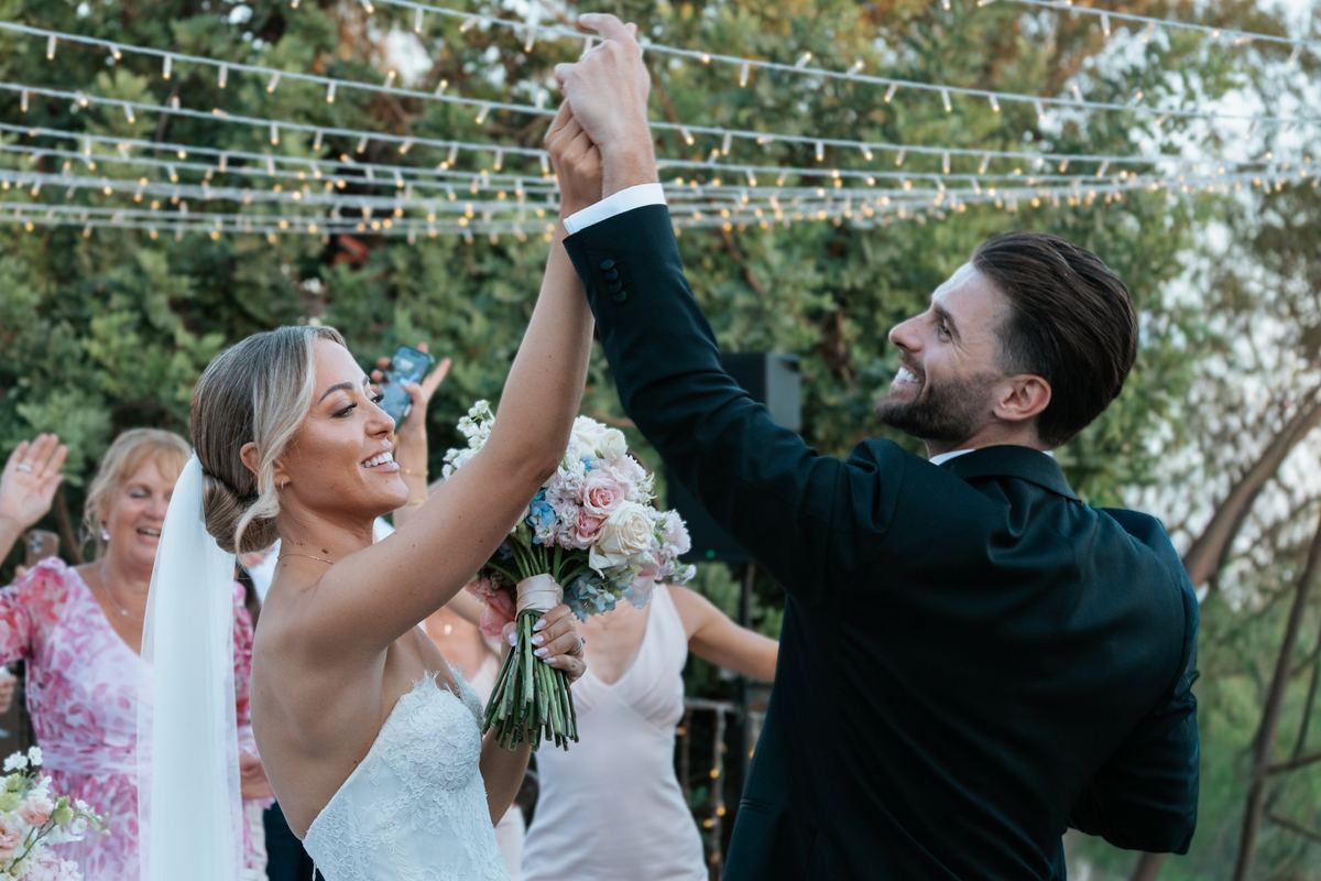Novia y novio celebrando con las manos en alto durante su boda en Casa de la Era, Marbella